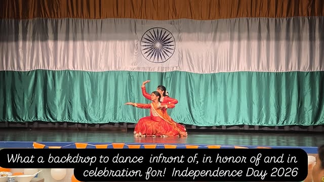 Two Kathak students performing on stage in front of an Indian flag backdrop on Independence Day
